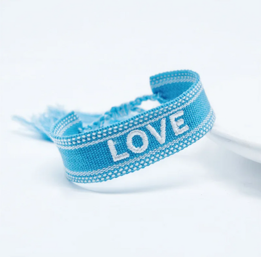 Bracciale in tessuto azzurro con scritta "love" ricamata bianca