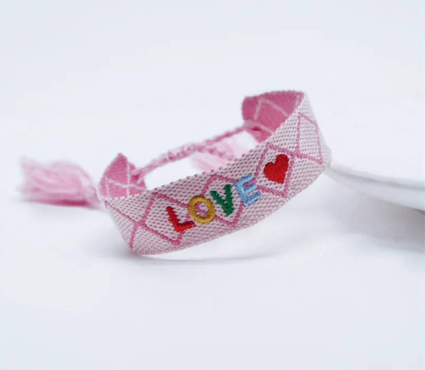 Bracciale in tessuto rosa con scritta "love" ricamata multicolor